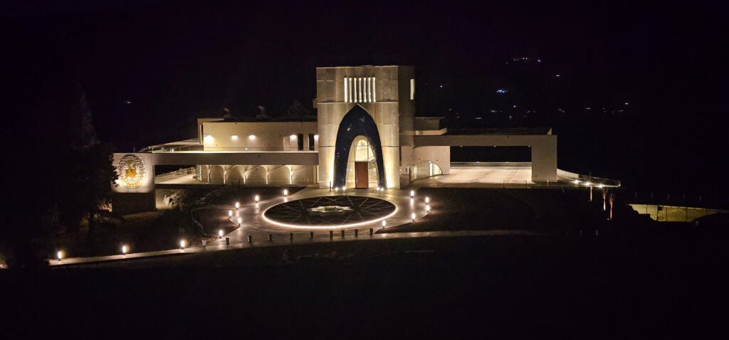 Night view of a modern architectural building with illuminated pathways.
