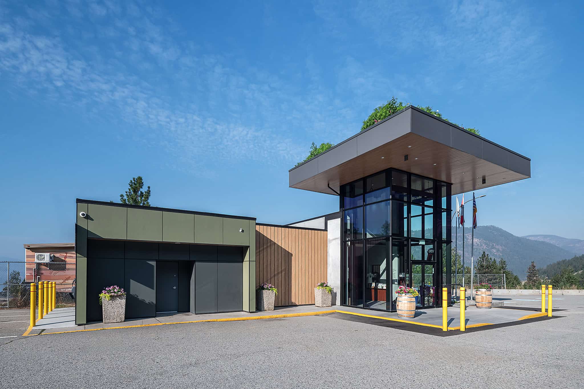 Contemporary visitor center with glass entrance and mountain view.